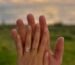 Oval diamond engagement ring on a hand at sunset